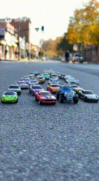 AI generated video: A brigade of hot wheels rolls down the street