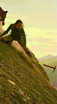 AI generated video: On a steep rocky mountain trail, a woman climber falls onto loose stones as a…