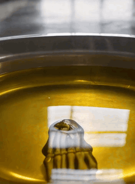 AI generated video: a close cropped cinematic video of a skeletal hand rising from a pool of oil…
