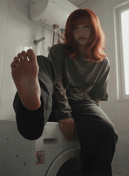 AI generated video: A low-angle handheld shot captures a woman with red hair sitting on a white…
