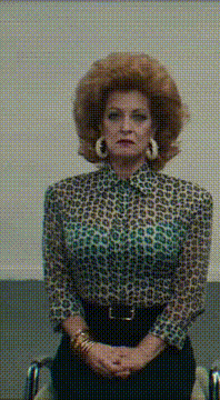 AI generated video: The scene opens in a medium close-up. A woman in her late 40s sits rigidly in…