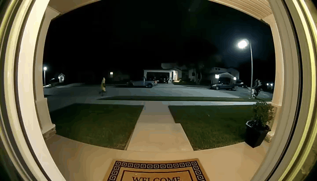 AI generated video: ring cam ,night time , man in banna suit run pass the the door exsplods