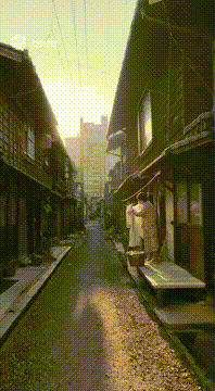 AI generated video: 1970年代の東京、朝7時頃。 街の外れにある木造家屋が並ぶ細い路地。 カメラは手持ち風のドキュメンタリー調で、路地をゆっくり進む。…