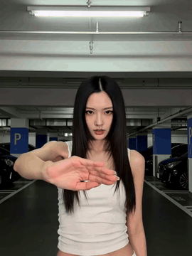 AI generated video: A woman extends her arm directly toward the viewer, placing her flexed palm…