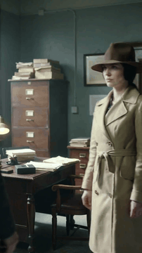 AI generated video: A humble noir woman in trenchcoat with hat hiding up all of her hair. She's…